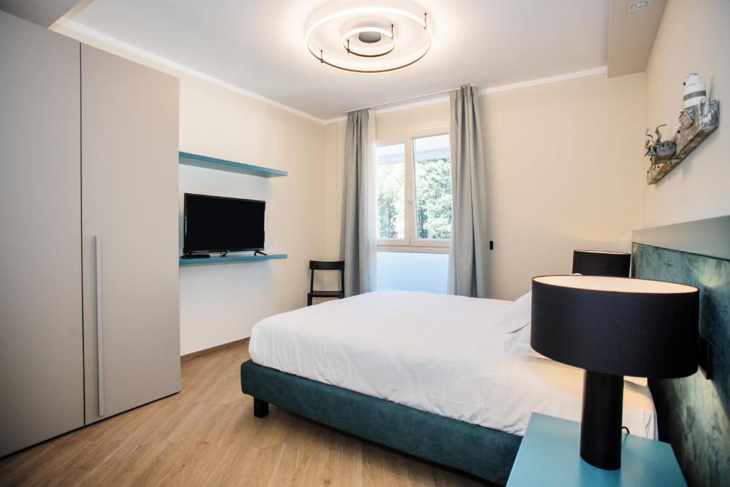 a bedroom with a bed and a flat screen tv at Hotel Barcarola 2 in Marina di Campo