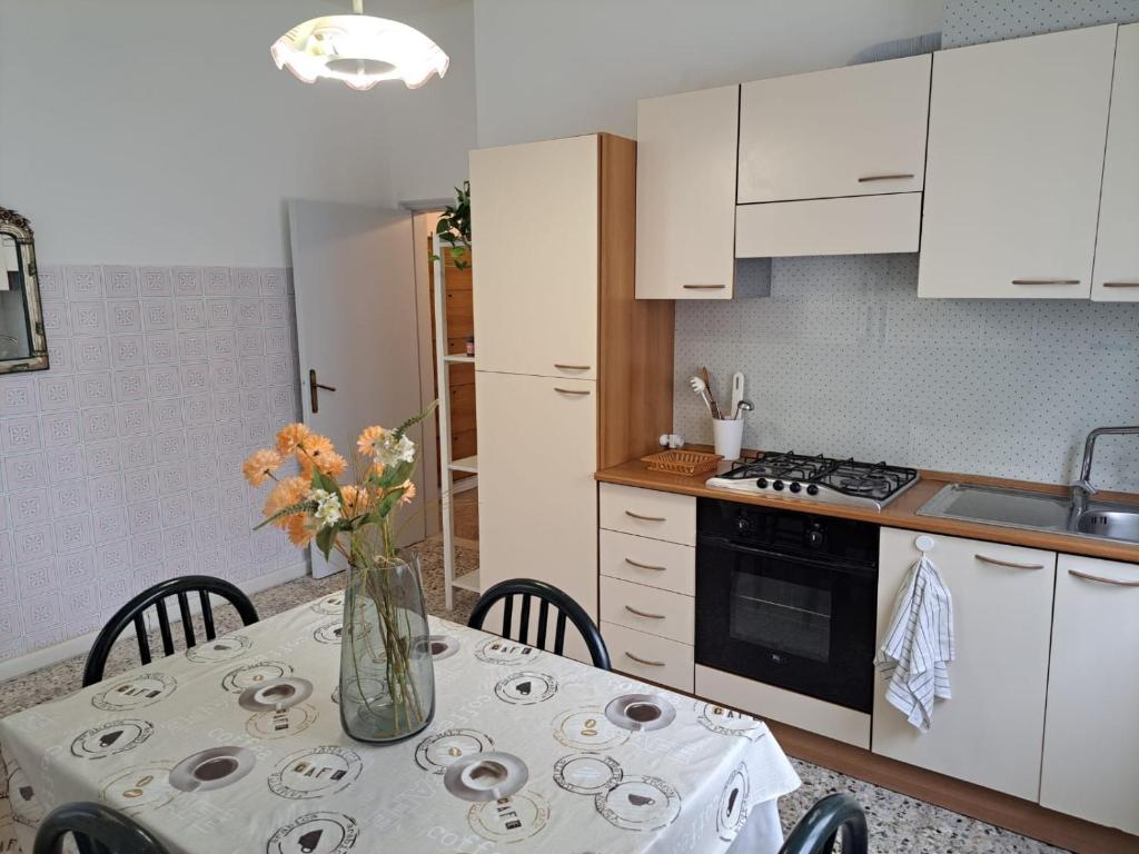 a kitchen with a table with a vase of flowers on it at Casa Gelsomino in Rimini