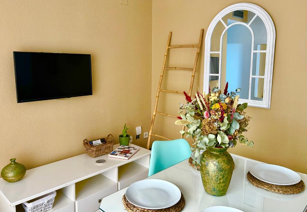 una sala de estar con una mesa con un jarrón de flores en Apartamento La Rosa - RECIÉN REFORMADO, en Córdoba