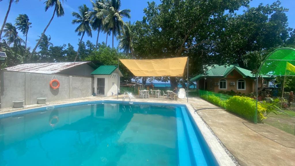 a large swimming pool in front of a house at Seaside traveler's Inn by Camiguin Island Home in Catarman