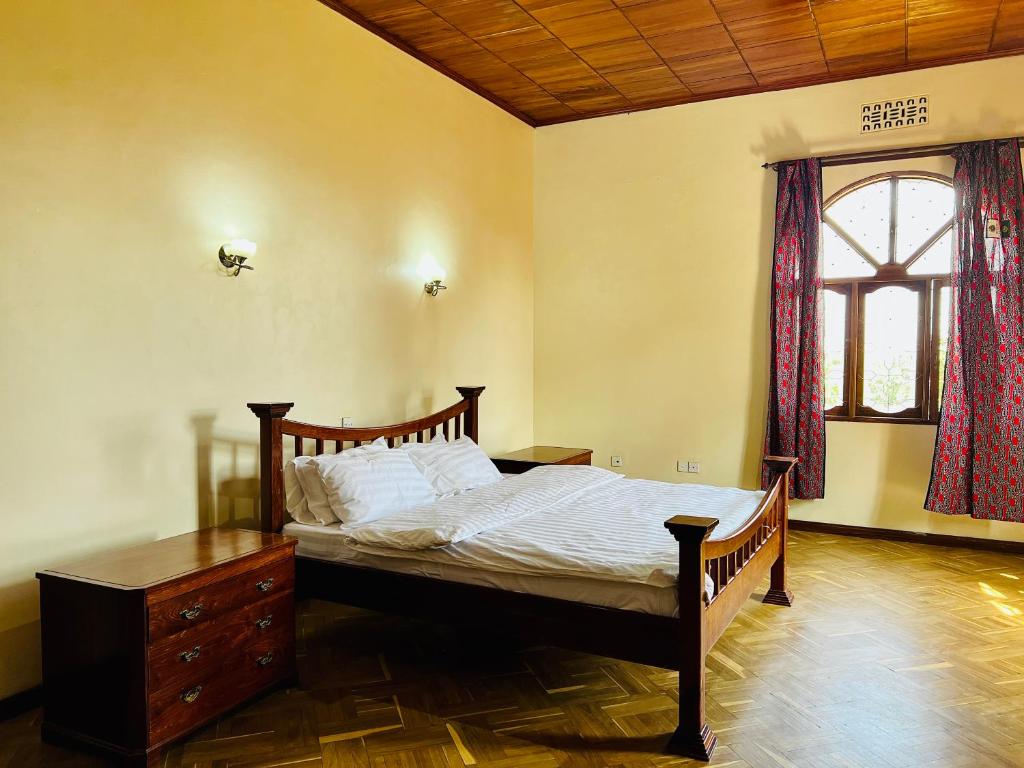 1 dormitorio con 1 cama, vestidor y ventana en Mahali Muzuri, Arusha, en Arusha