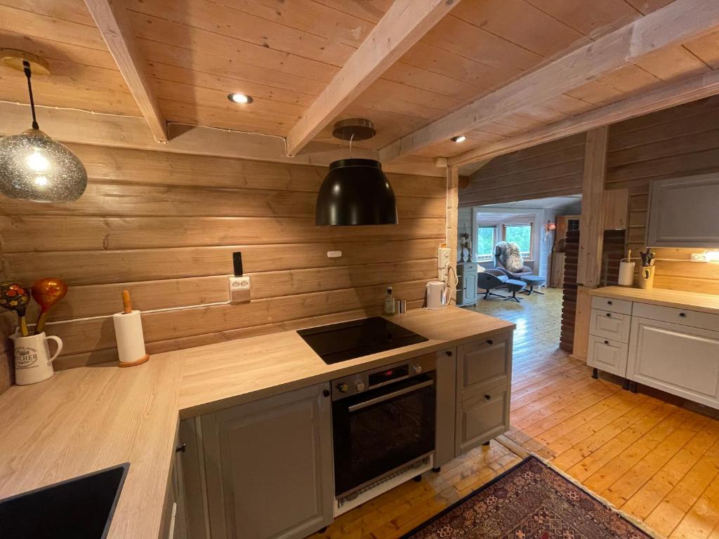 uma cozinha com paredes de madeira e um forno com placa de fogão em Large and cosy mountain cabin em Sykkylven