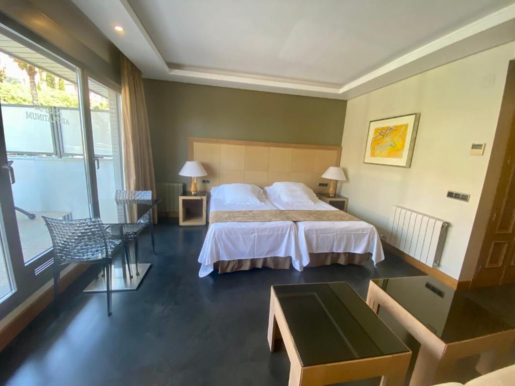 een slaapkamer met een bed en een groot raam bij ArtPlatinum SUITES&APARTMENTS in Benalmádena