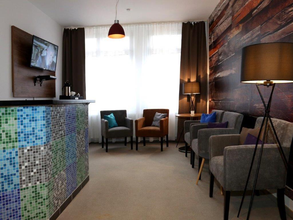 una sala de espera con sillas y un colorido mosaico en la pared en Arthotel, en Bad Pyrmont