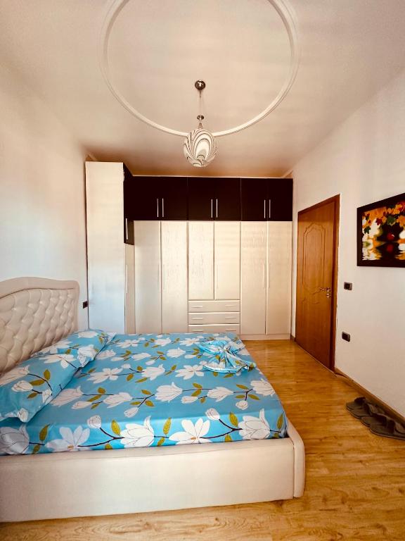 um quarto com uma cama com um edredão azul em SleepIn Shkoder em Shkodër