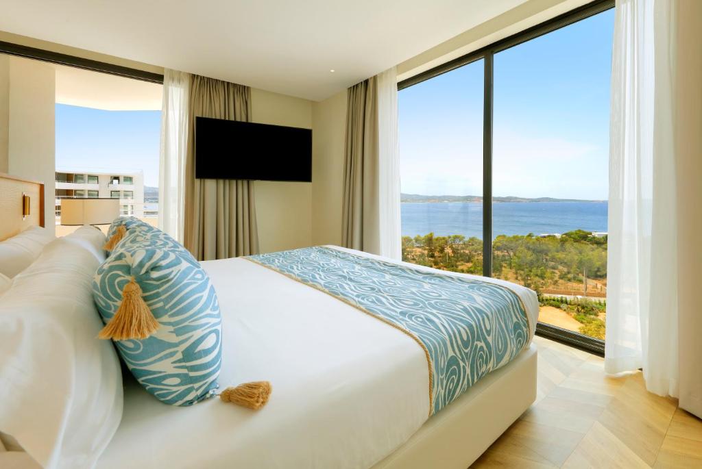 a bedroom with a large bed with a large window at TRS Ibiza Hotel - Adults Only in San Antonio