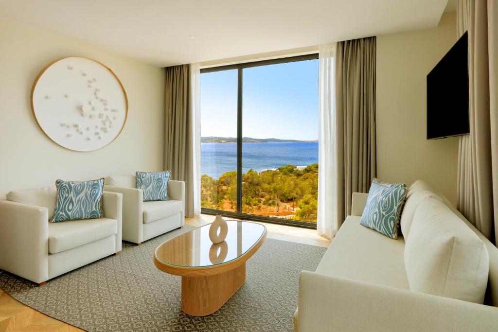 a living room with white furniture and a large window at TRS Ibiza Hotel - Adults Only in San Antonio