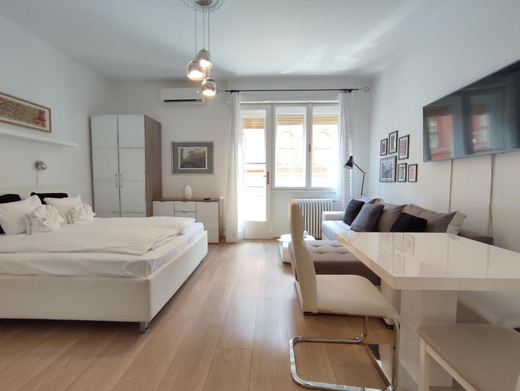 a white bedroom with a bed and a couch at Buda Home in Budapest