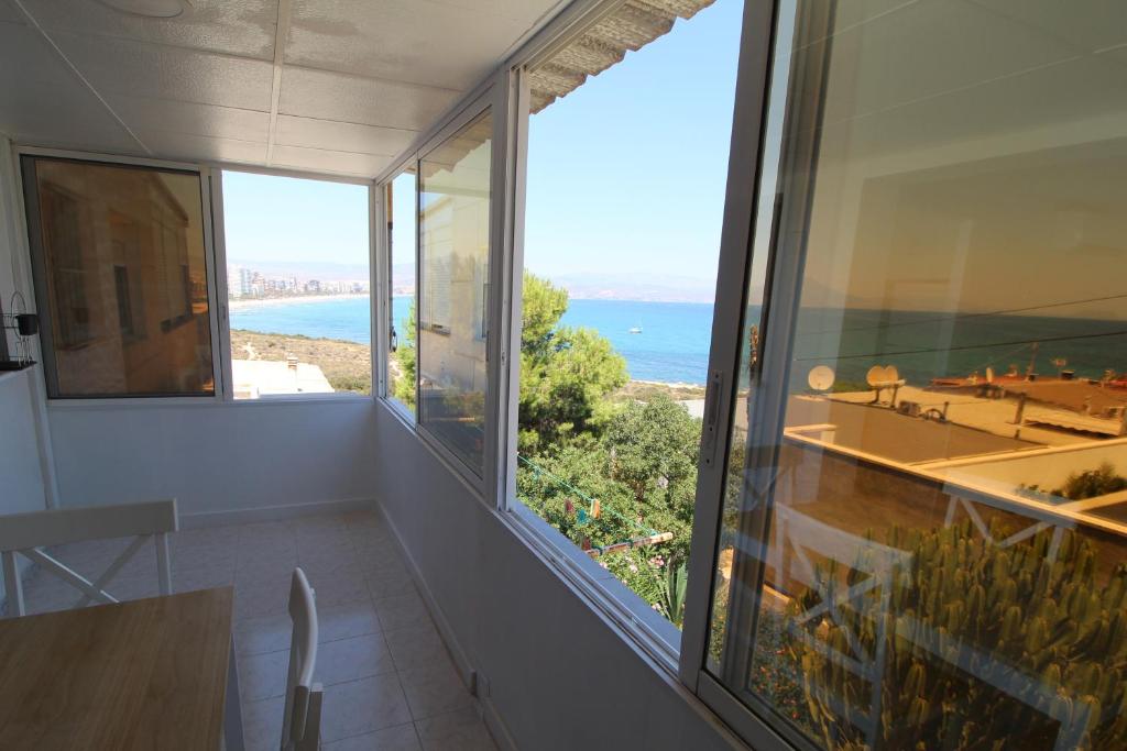 a dining room with a view of the ocean at Amazing views of Cabo de las Huertas. 1 min walk Cabo de las Huertas beach. 4 mins walk Playa de San Juan beach in Alicante