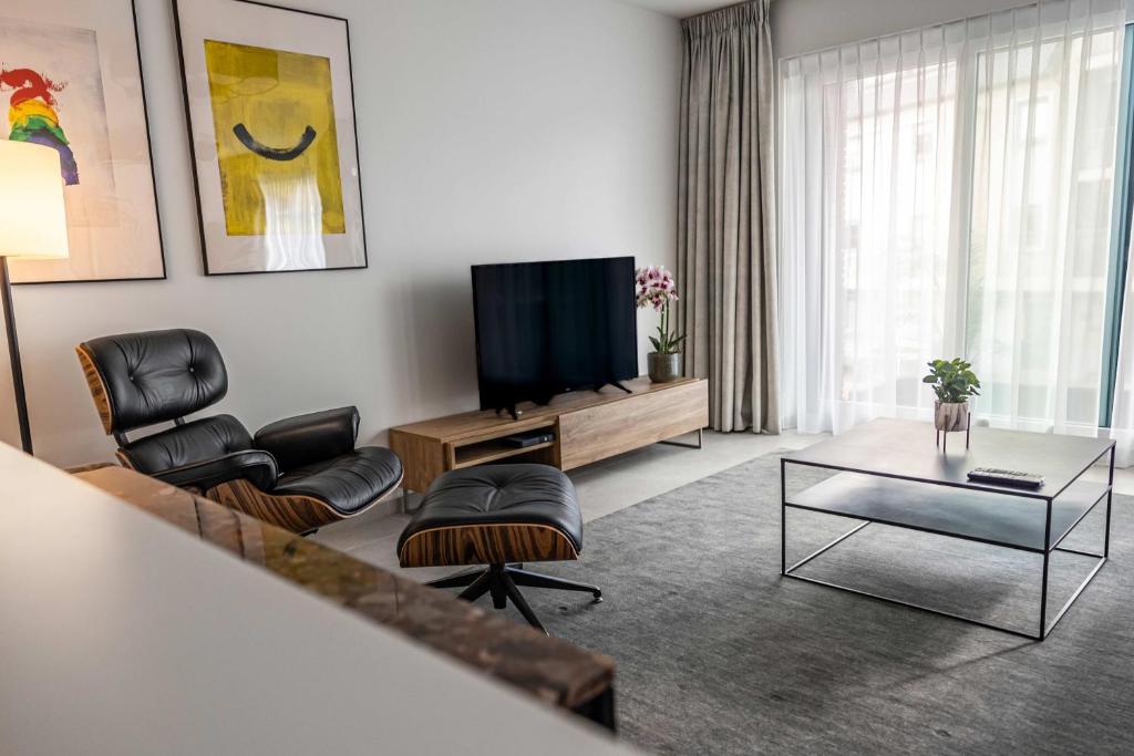 a living room with a flat screen tv and chairs at Casselbergh Residences Leader - De Haan in De Haan
