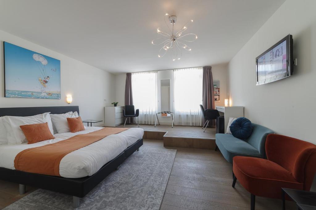 ein großes Schlafzimmer mit einem großen Bett und einem Sofa in der Unterkunft Hotel De Zilte Zeeuw in Kortgene