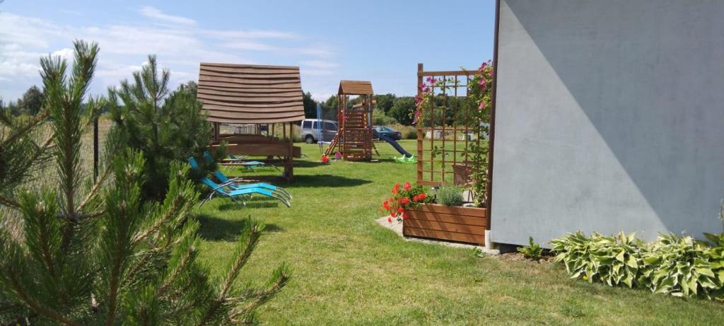 a yard with two chairs and some plants at Domki Afrodyta in Jarosławiec