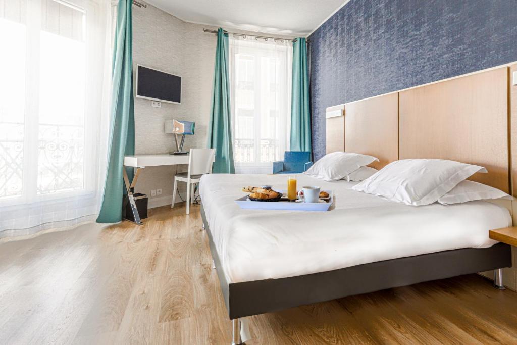 Un dormitorio con una cama grande y una bandeja de comida. en Hotel Amiraute, en Cannes