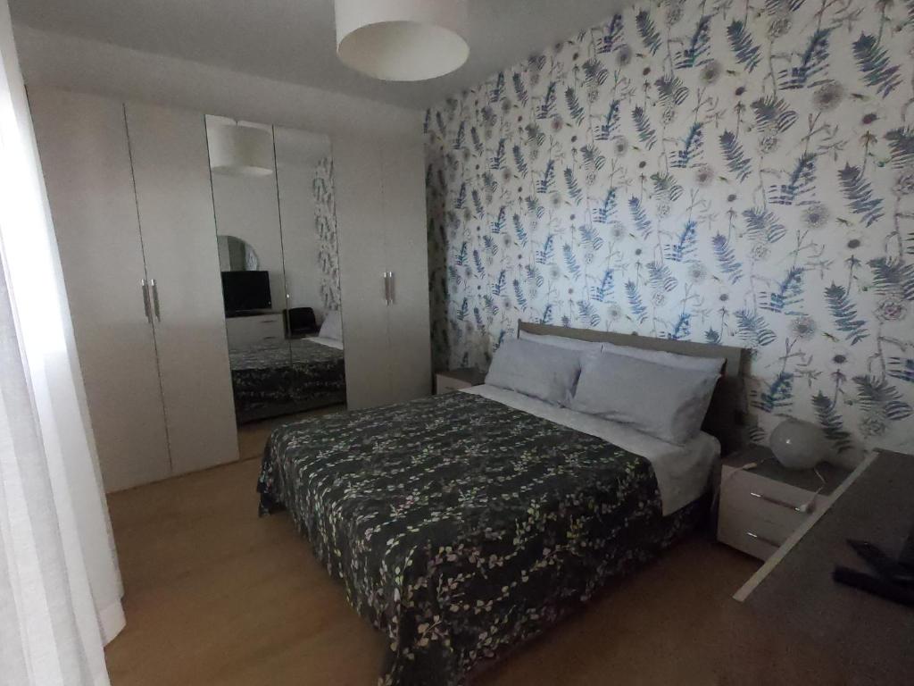 a bedroom with a bed with a blue and white wallpaper at Appartamento Sicilia vicino Caltagirone - Niscemi in Niscemi