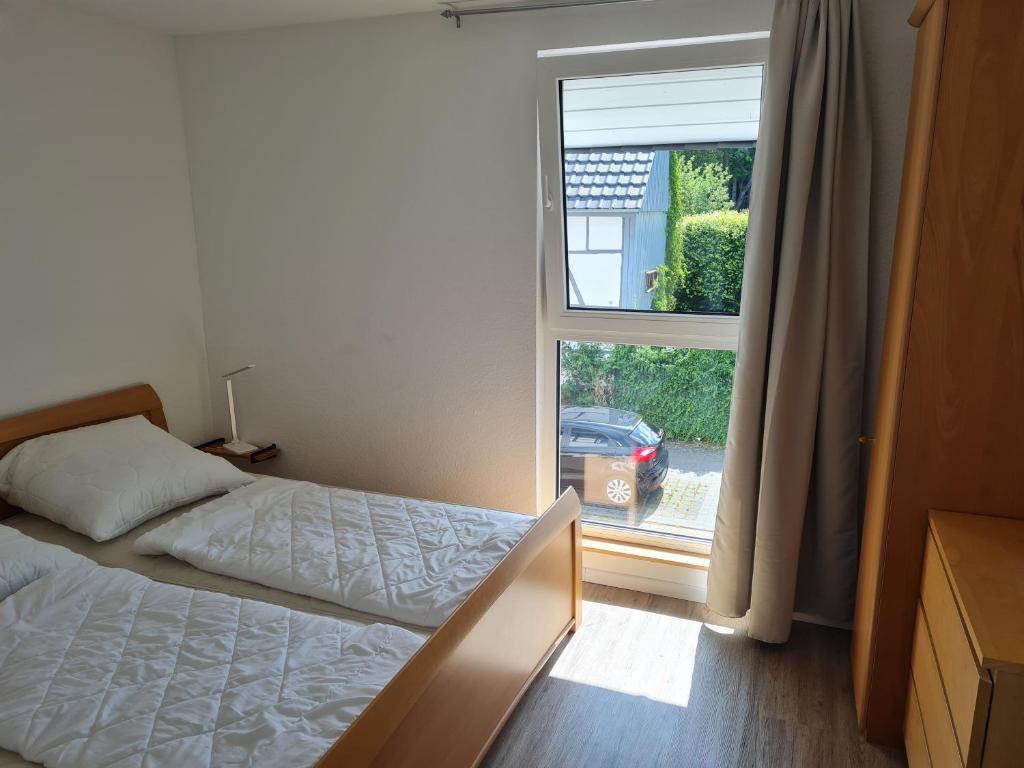 a bedroom with a bed in front of a window at Ferienwohnung am Rursee in Simmerath