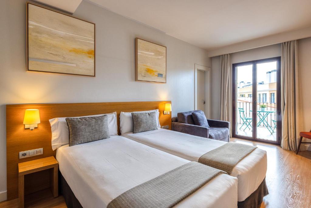 a hotel room with a large bed and a window at Arc La Rambla in Barcelona