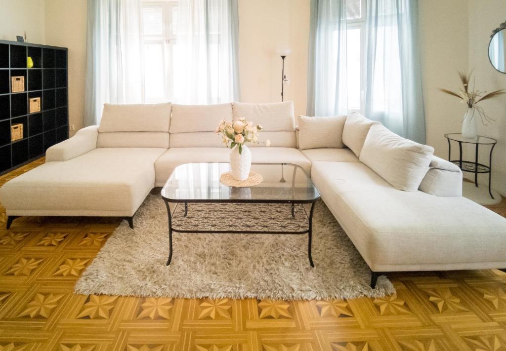 a living room with a white couch and a coffee table at Luxury Vincents Apartments Kosice in Košice