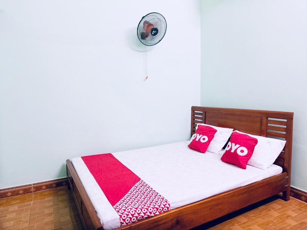 a bedroom with a bed with red pillows and a fan at SPOT ON 1186 Nha Nghi Huong Mai in Da Nang