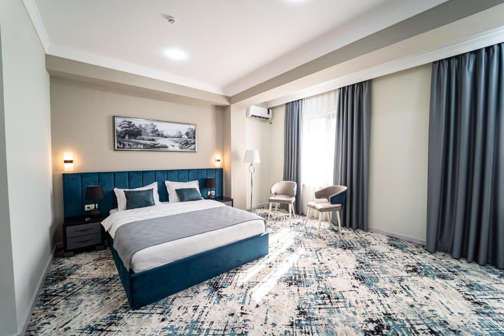 um quarto de hotel com uma cama e uma janela em Hamilton em Tashkent