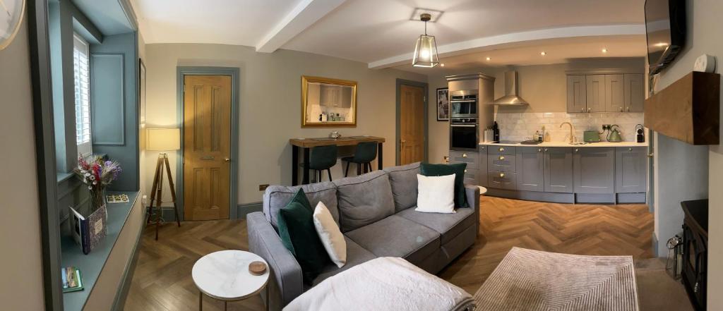 a living room with a couch and a kitchen at The Ebor Suite a cosy apartment in Haworth in Haworth