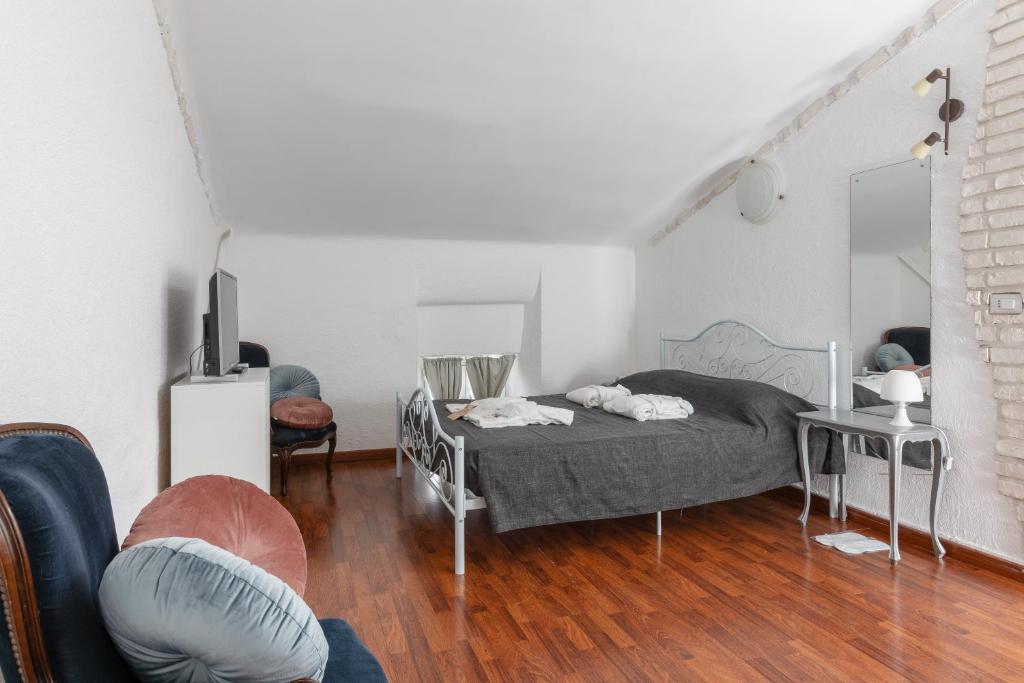 um quarto com uma cama e uma cadeira num quarto em Loft Rossetti em Trieste