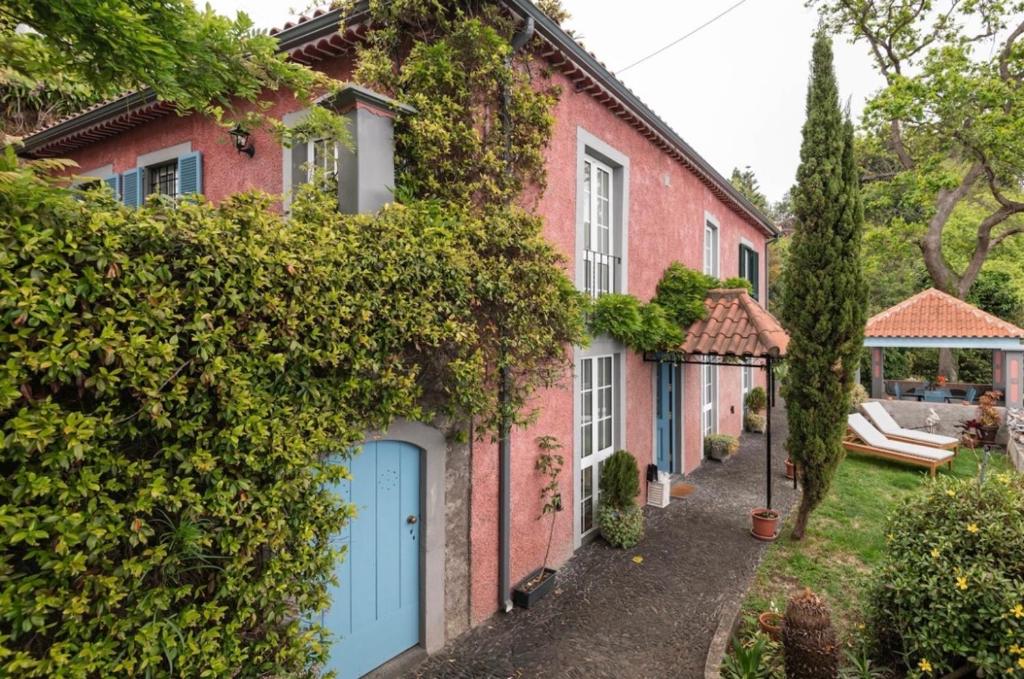 uma casa de tijolos com portas azuis e hera em Quinta Belmonte Funchal no Funchal