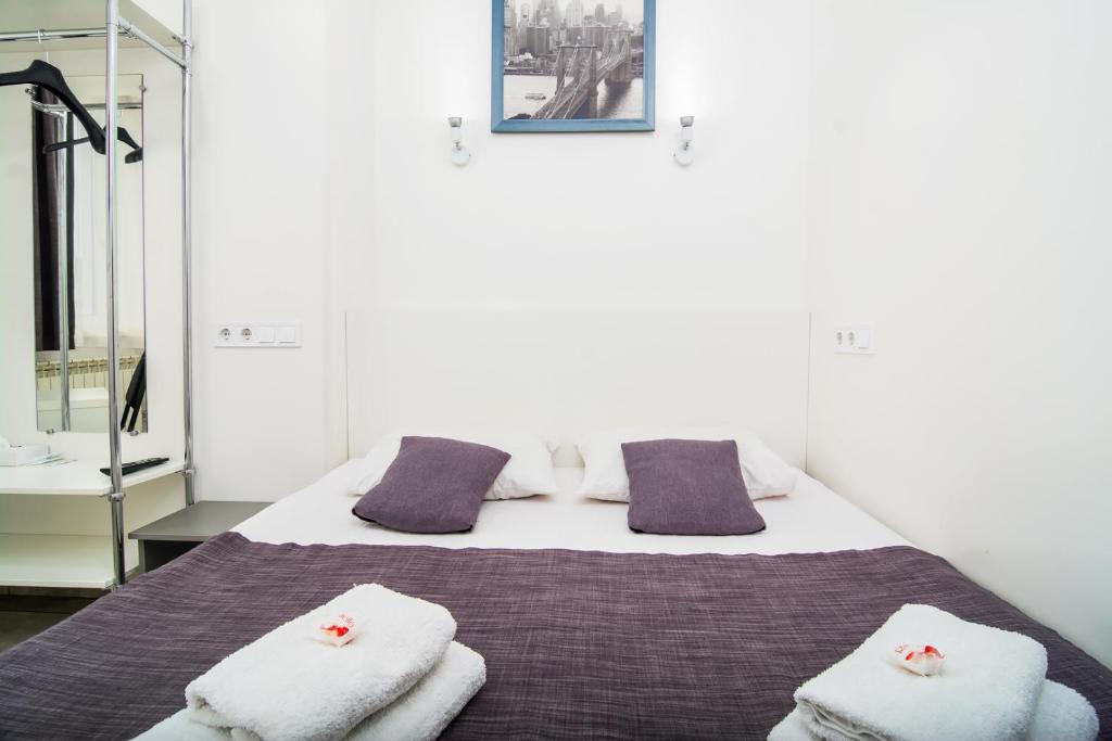 sypialnia z łóżkiem z ręcznikami w obiekcie Smart Hotel Rooms near metro 24/7 w Kijowie