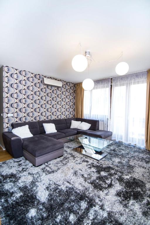 ブダペストにあるPaulay free parking luxury design apartman with terazzeの黒いソファとガラスのテーブルのあるリビングルーム