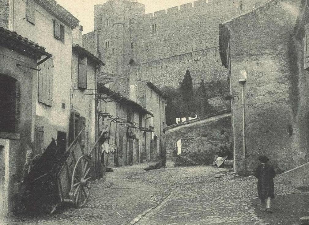 a person walking down a street in an alley at Maison des Remparts nichée sous la Cité in Carcassonne