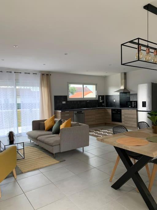 un salon avec un canapé et une table dans l'établissement Charmante Villa, à Châtellerault