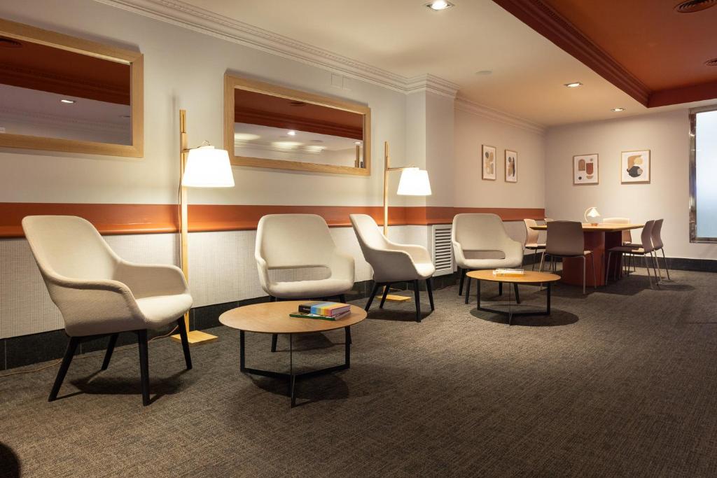 a waiting room with chairs and tables and lamps at Arc La Rambla in Barcelona