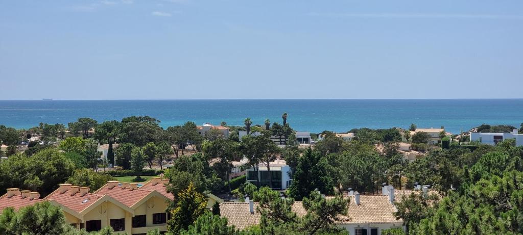 a view of a neighborhood with houses and the ocean at Soltroia Dunas House in Troia