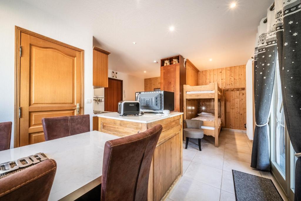 une cuisine avec une table et des chaises dans une pièce dans l'établissement Au rêve savoyard 2 - 4 personnes, à Morillon