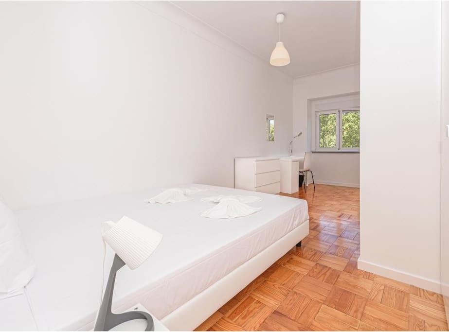 una camera bianca con letto e scrivania di HOUZE_4 room flat in Lisbon Centre near Zoo a Lisbona