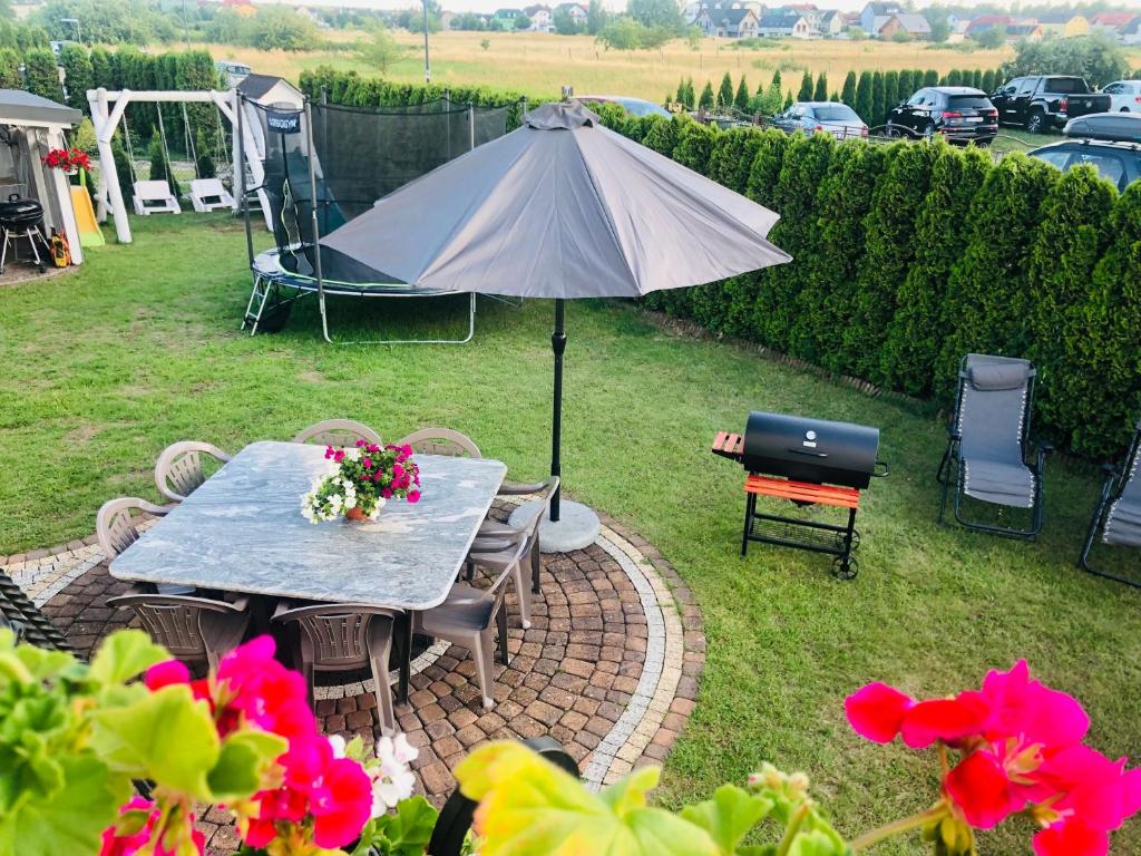 a table with an umbrella in a yard at Julus in Łeba
