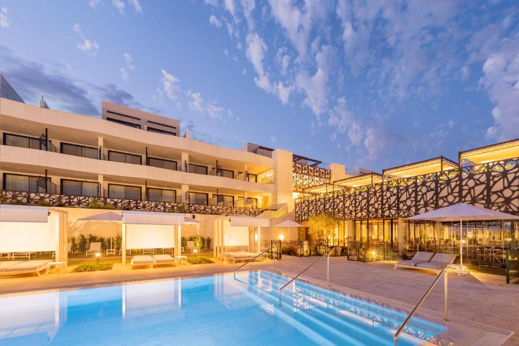 un hotel con piscina frente a un edificio en Eurostars Oasis Marbella, en Marbella