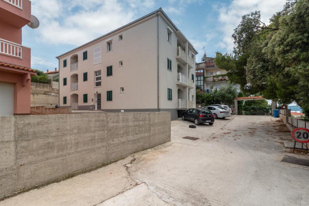 un edificio con una pared de retención junto a un aparcamiento en A3 apt with balcony and sea view 3 min to beach, en Trogir