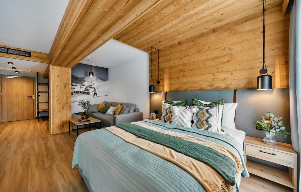 ビャウィ・ドゥナイェツにあるTatra Nest Apartamenty - jacuzzi, sauna!のベッドルーム(大型ベッド1台、ソファ付)