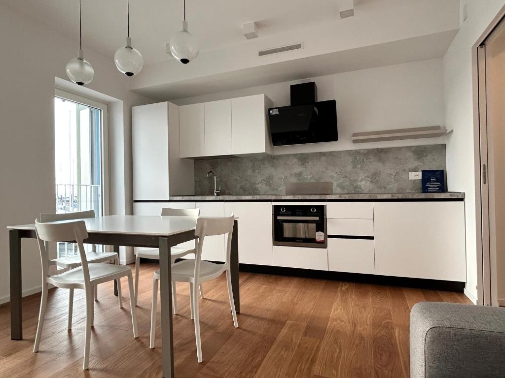 uma cozinha e sala de jantar com mesa e cadeiras em Montecarlo Seaview Apartment em Chioggia