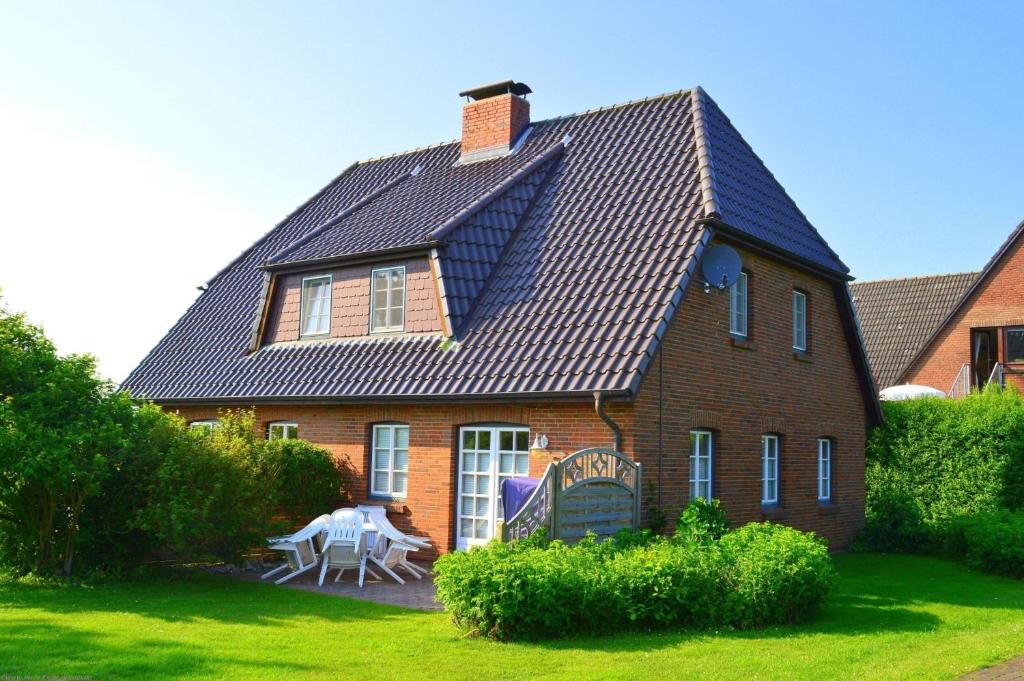 a house with a roof with a table in the yard at Osterharde in Wrixum