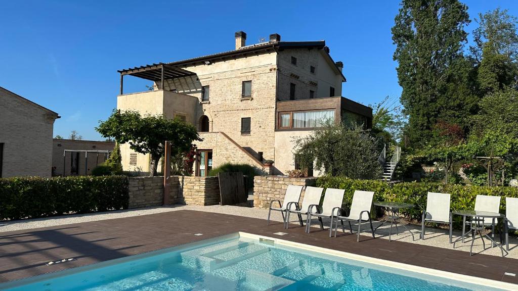 a house with a swimming pool in front of a building at Agriturismo nelle Marche in Montalto delle Marche