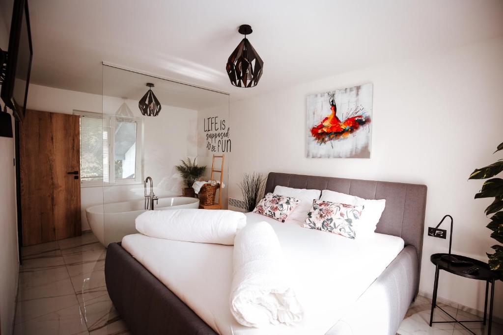 sypialnia z białym łóżkiem i łazienką w obiekcie Holiday House Sunset Spa w mieście Šentjernej