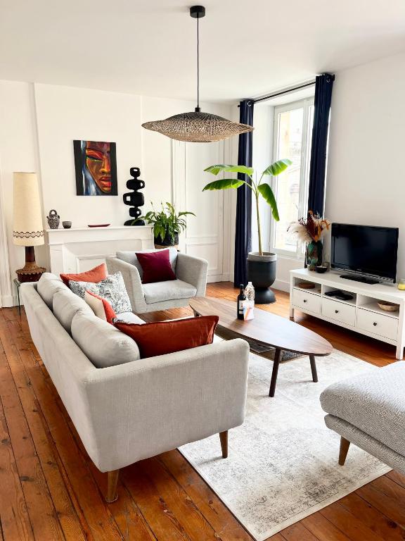 un salon avec un canapé et une télévision dans l'établissement Bordeaux hypercentre - Grand Theatre - Opera - Parlement - Bourse, à Bordeaux