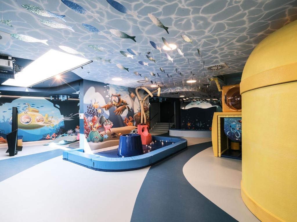 a childrens room with a ceiling decorated with cartoon animals at Falkensteiner Family Hotel Diadora in Zadar