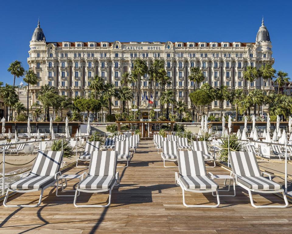 Carlton Cannes, a Regent Hotel في كان: صف من الكراسي امام المبنى