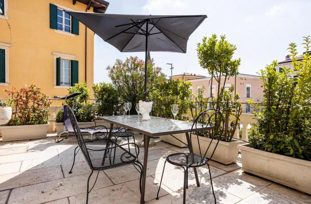 a table and chairs with an umbrella on a patio at Juliet's Green Terrace [FREE PARK] in Verona