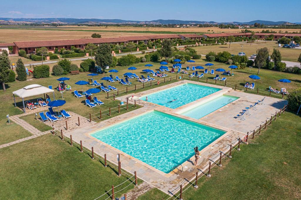 una vista sul soffitto di una piscina con sedie e ombrelloni di Residenza Principina a Principina Terra