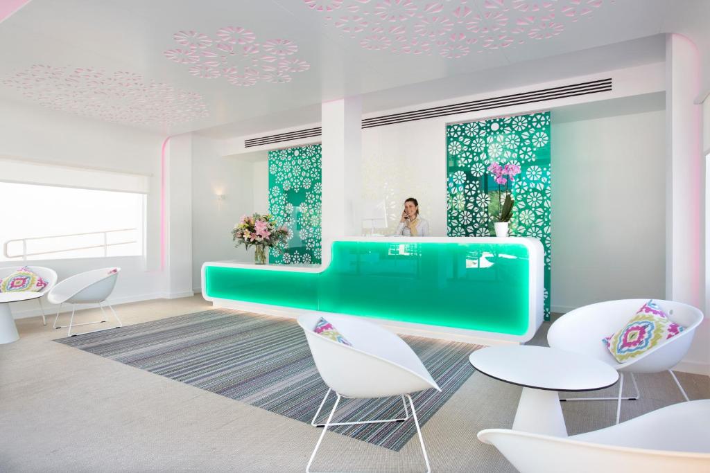 a room with a green table and white chairs at Grupotel Ibiza Beach Resort - Adults Only in Portinatx