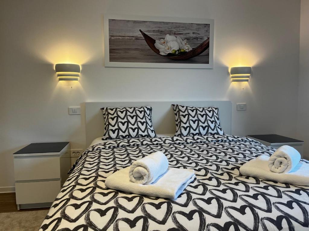 una camera da letto con un letto bianco e nero con asciugamani di Villa Kovačeva 15, app 1, free parking a Lubiana