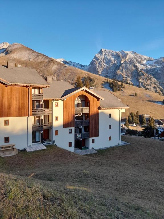マニグードにあるAppartement au cœur des Aravisの山を背景にした丘の上の住宅